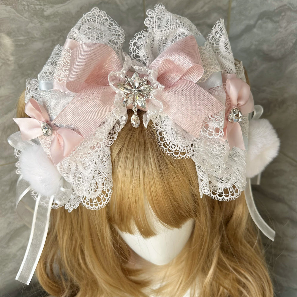 Lace-framed red bow headband with jeweled center, pom-poms and trailing ribbons.