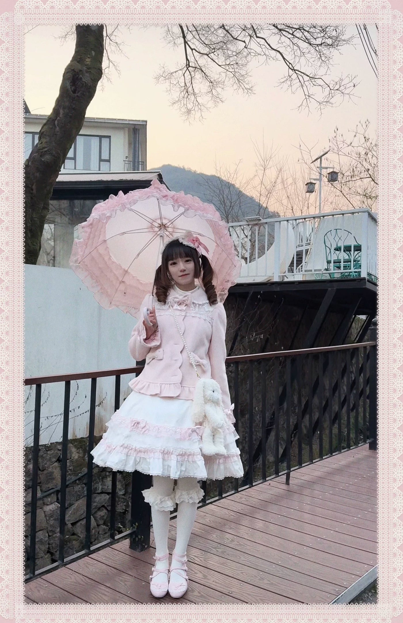 Pink Lolita coat with a ruffled hem and lace-trimmed collar worn on a model.