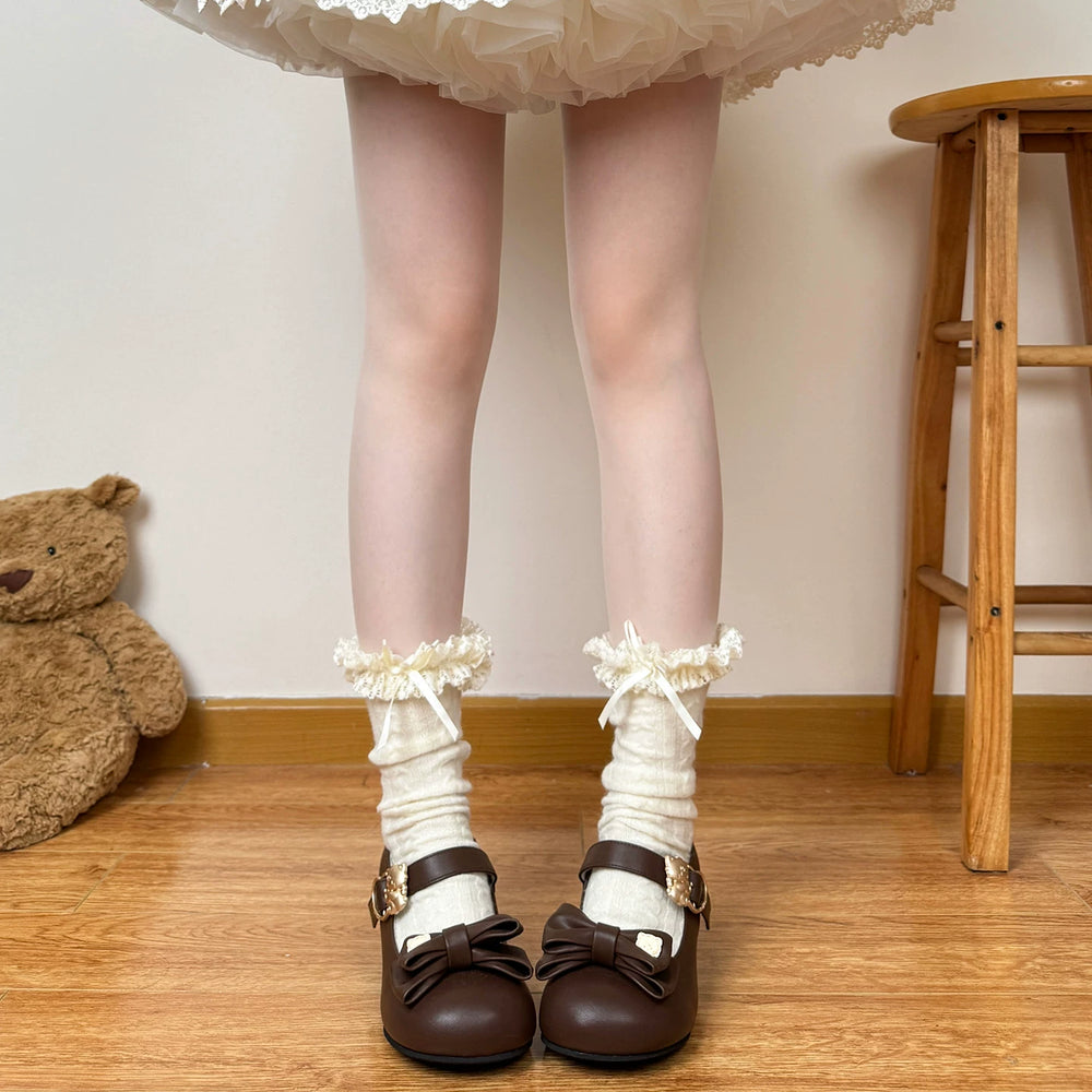 Beige lace sock designs styled with a voluminous cream skirt and brown shoes.