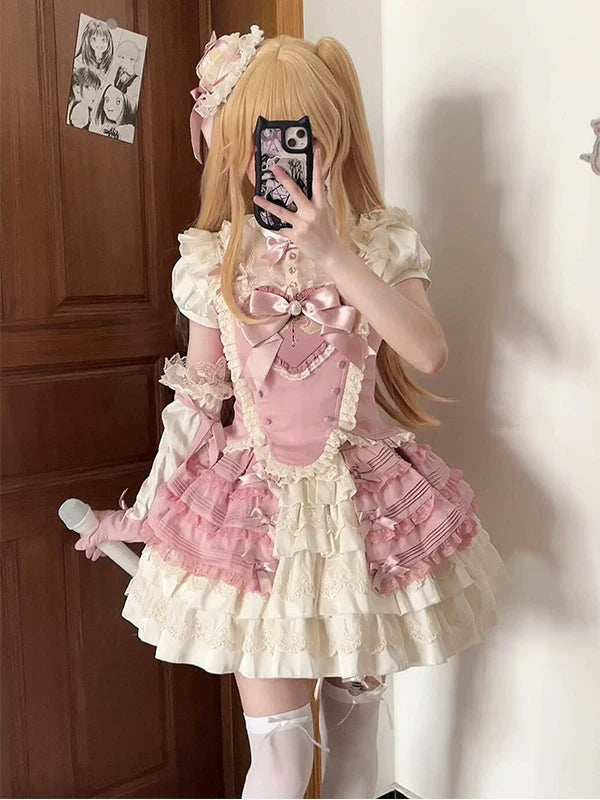 Pink-and-cream Lolita blouse-and-skirt set worn with layered ruffles and a large bow.