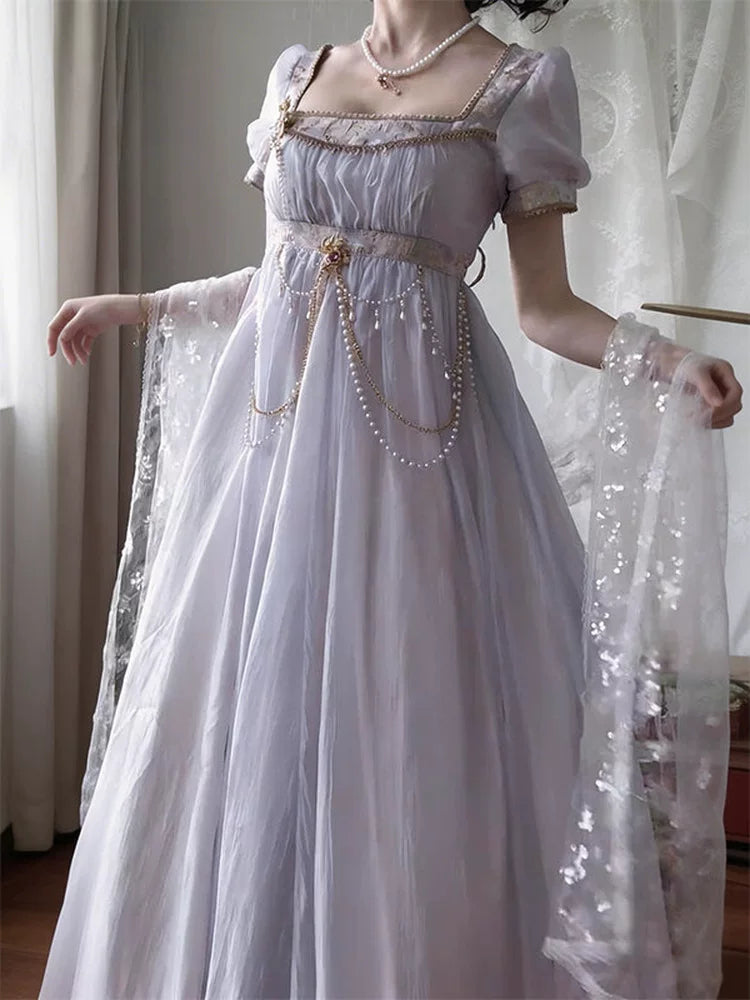 Creamy purple empire-style dress with puff sleeves, pearl draping and a flowing skirt, shown on a model.