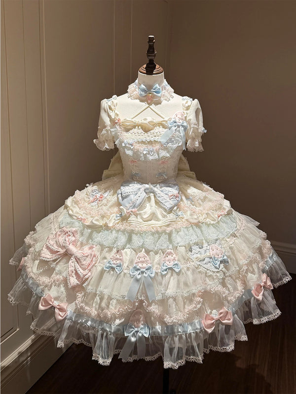 Pastel cream, blue and pink Lolita OP dress with layered lace tiers and a large train on a mannequin.
