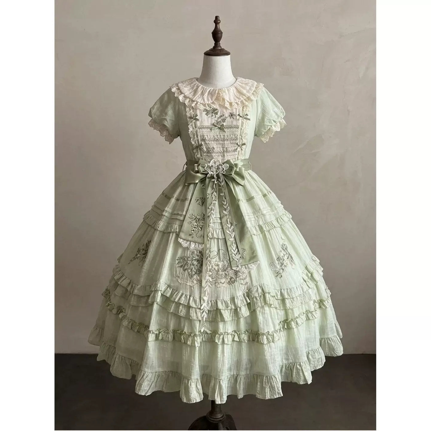 Close-up of embroidered grape and floral motifs on the dress bodice and skirt