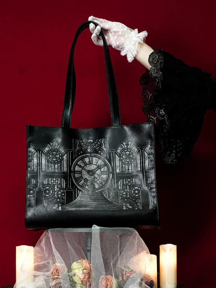 Black tote bag with a silver clock-tower and central clock graphic against a deep red backdrop.
