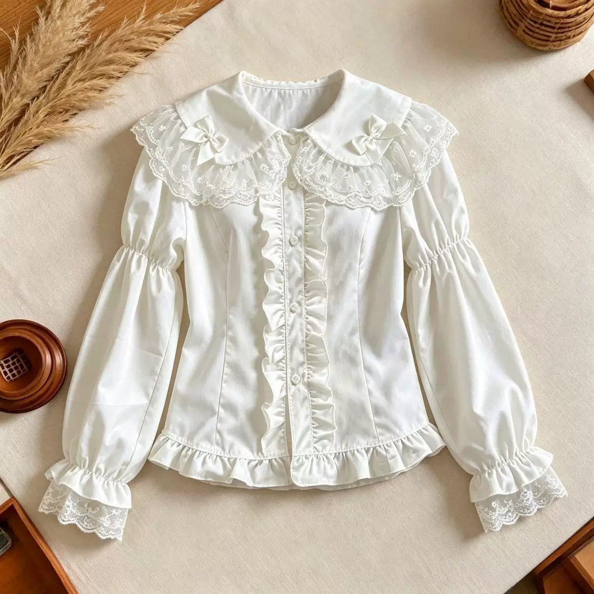 Ivory-white long-sleeve Lolita blouse with lace collar, bows and gathered cuffs
