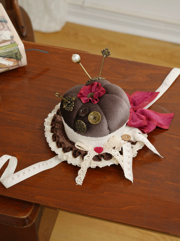Sewing-inspired mini hat with lace, bows, buttons and measuring-tape ribbons.