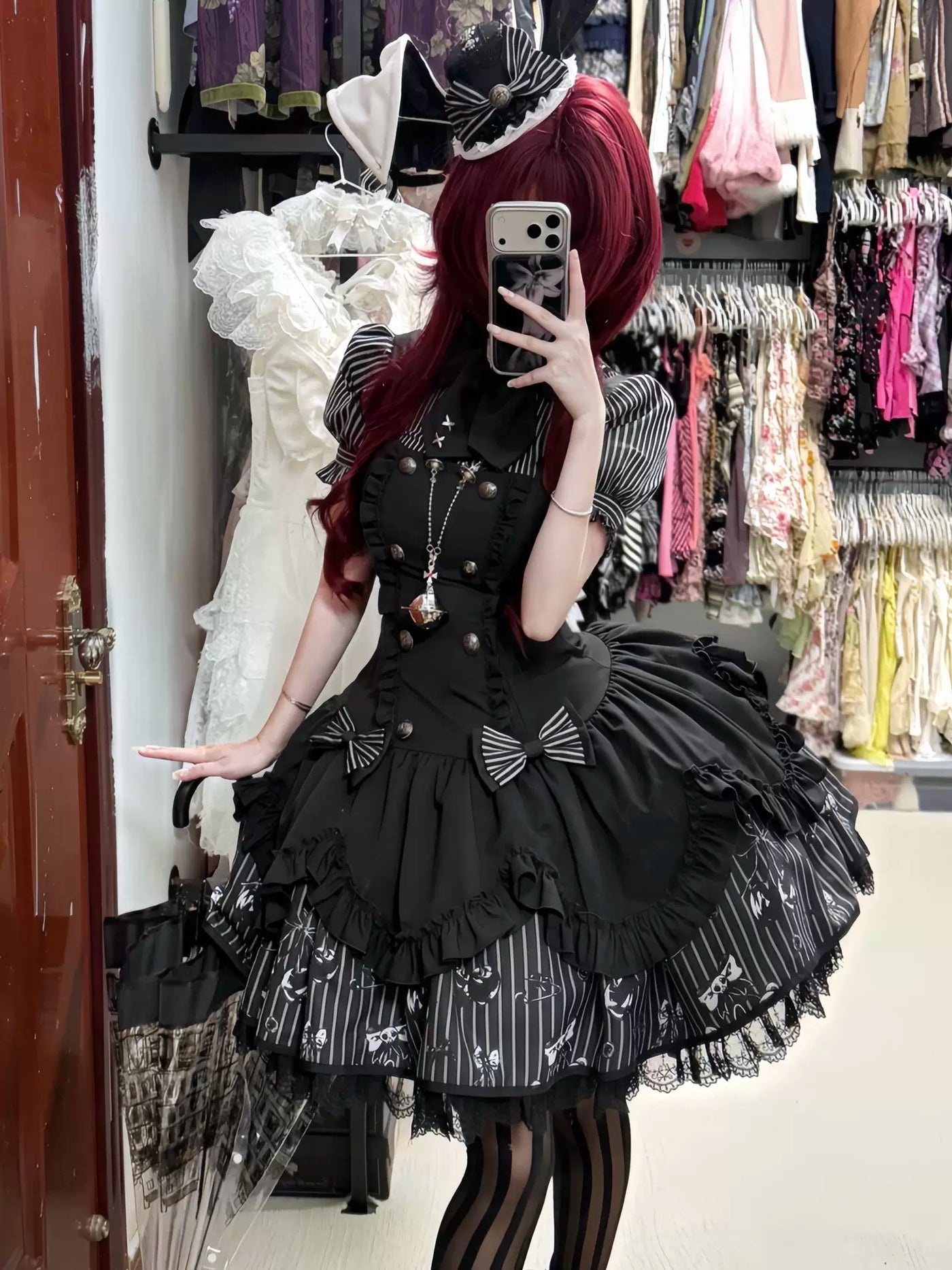 Black JSK with striped puff sleeves, bows and layered ruffles shown in a mirror.