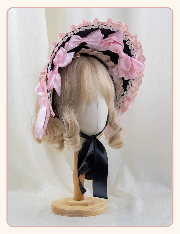 Pink and black Lolita headwear with polka-dot bows and lace trim displayed on mannequins.