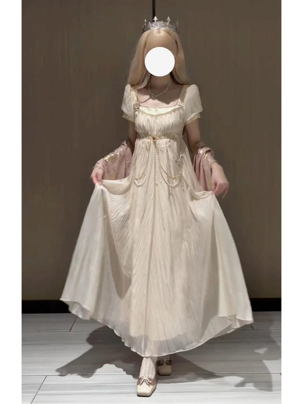 Model wearing a gilded gold-colored empire-style Lolita dress with a waist chain.