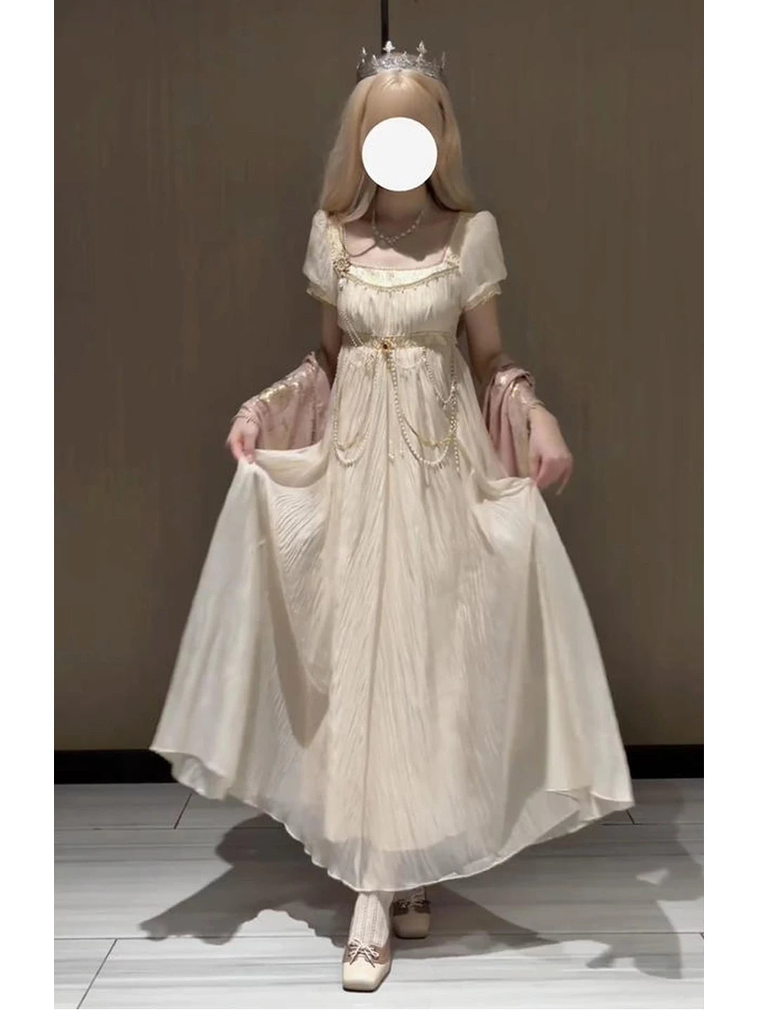 Model wearing a gilded gold-colored empire-style Lolita dress with a waist chain.