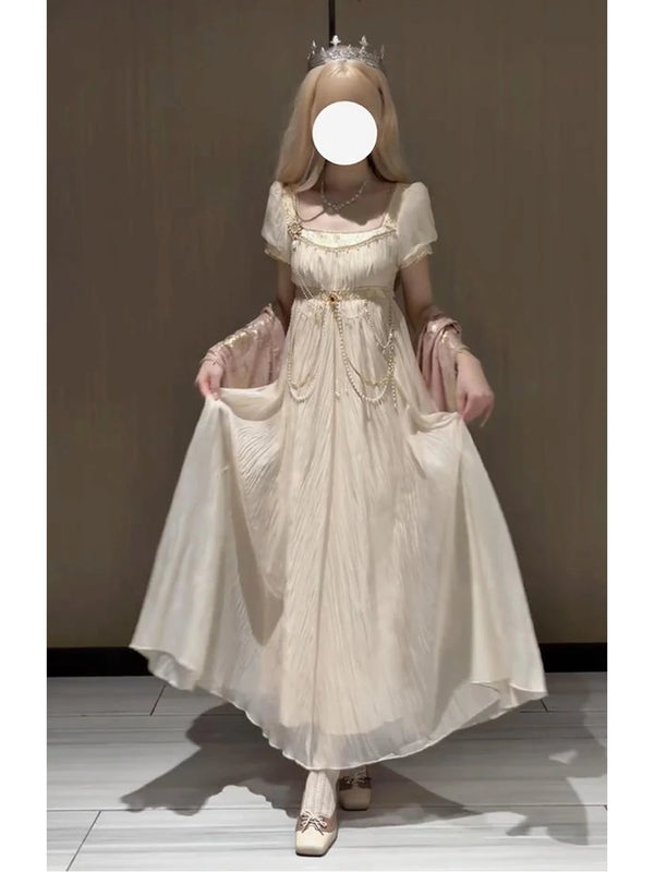 Model wearing a gilded gold-colored empire-style Lolita dress with a waist chain.