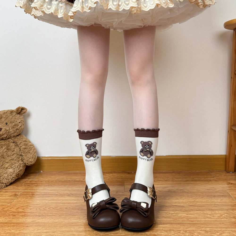 Model wearing brown-and-cream mid-calf socks with bear motifs and stripes.