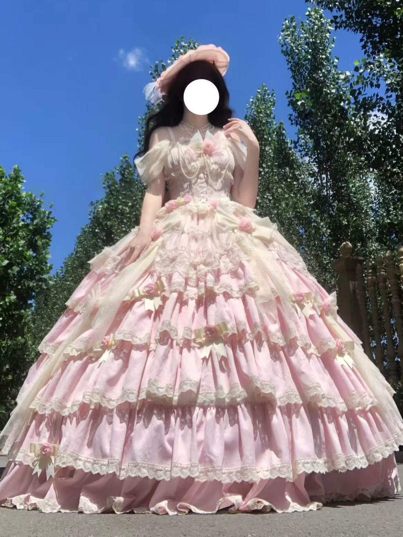 Front view of pink Lolita dress showing corset lacing and large satin waist bow with pearl accents