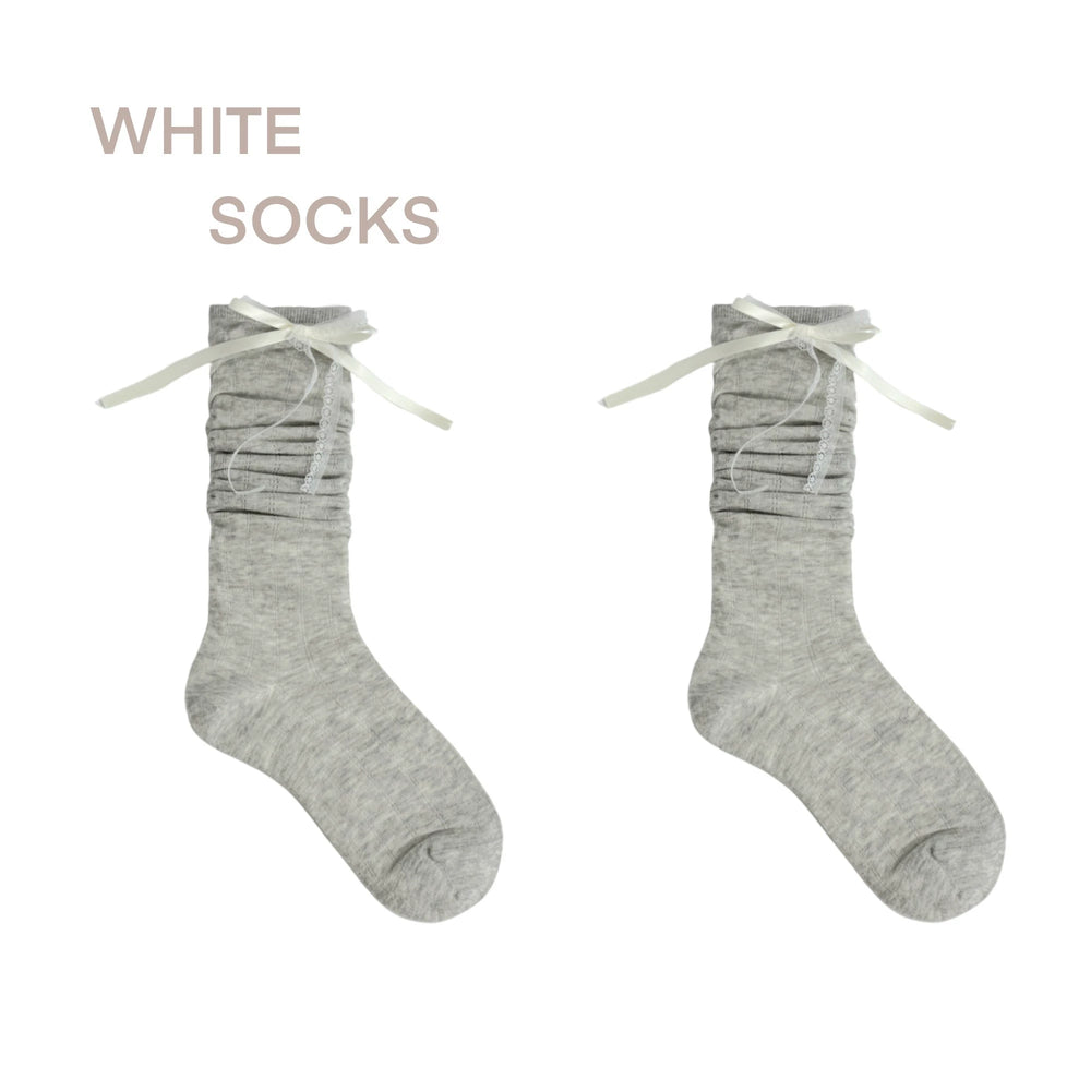 Model wearing white and gray lace slouch socks with black Mary Jane shoes