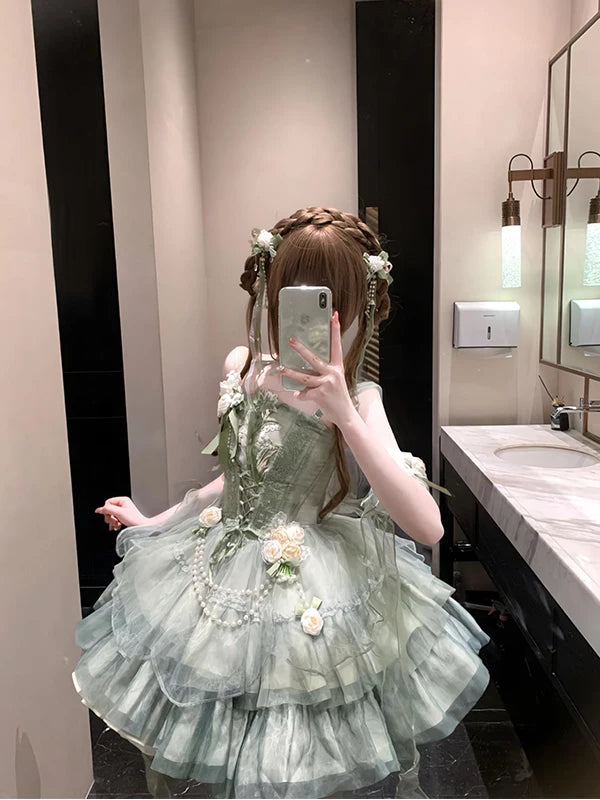 Mirror selfie of a green embroidered JSK dress with layered ruffles and floral accents.