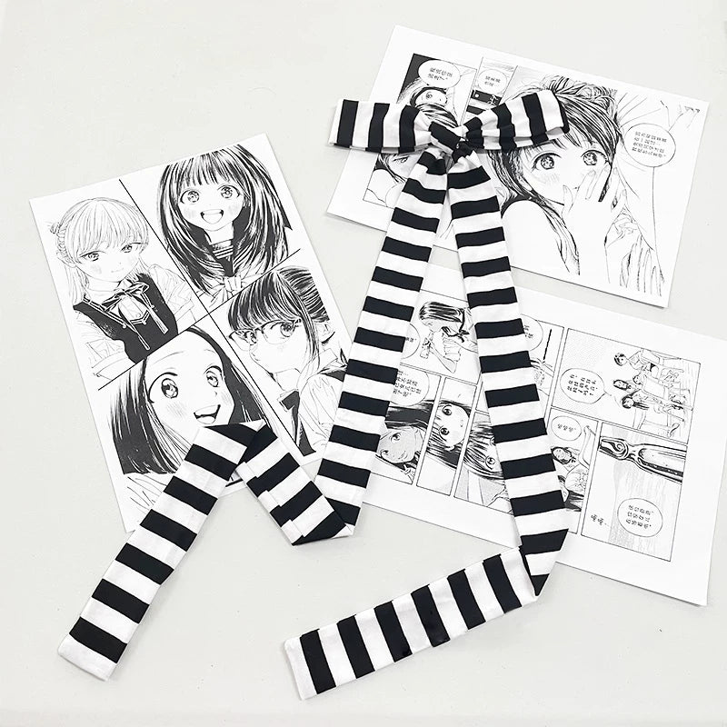 Black-and-white narrow striped scarf arranged with a bow and long ends