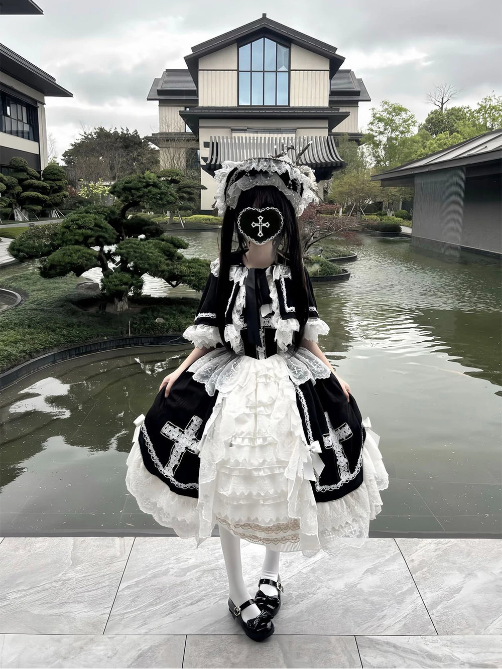 Black-and-white JSK dress with lace cape and hat in a garden setting