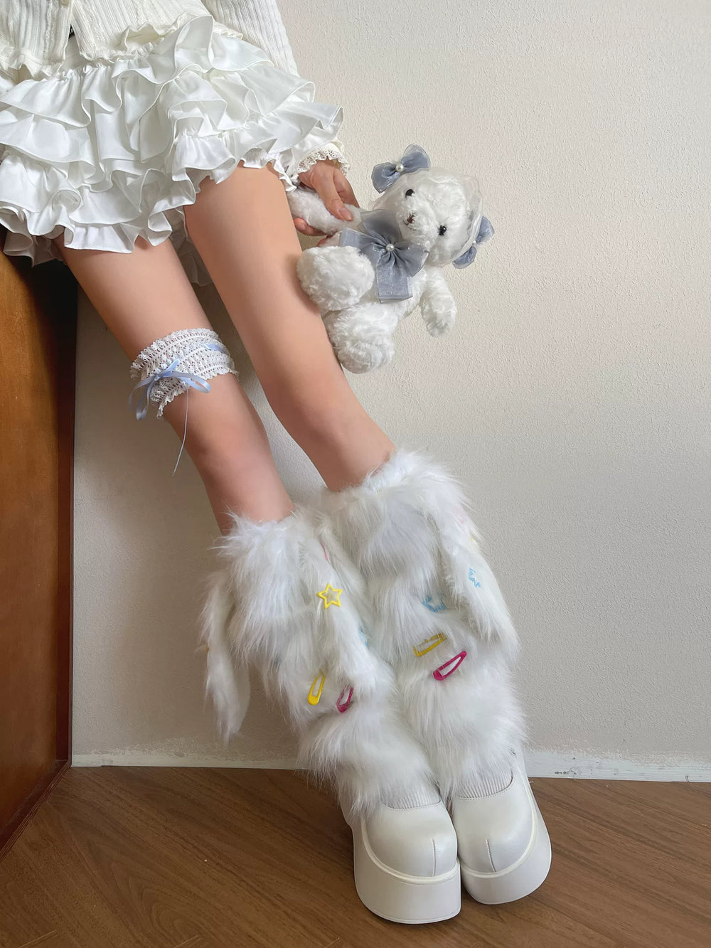 White fuzzy sock covers with colourful clip accents and a white-and-blue ribbon thigh garter.