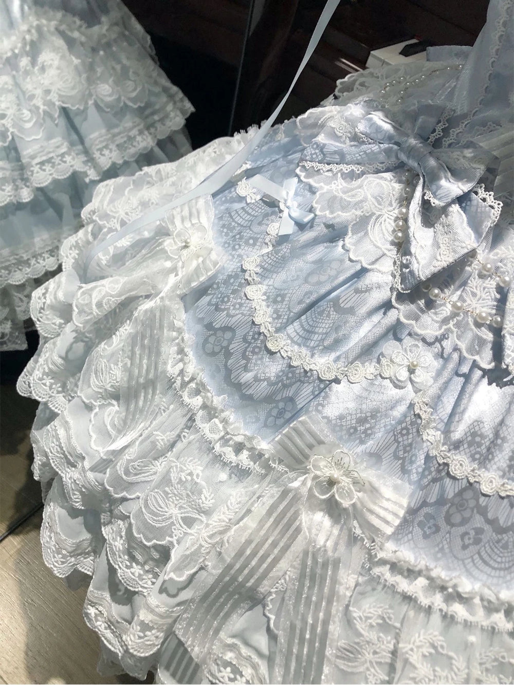 Creamy blue JSK dress with layered lace and bows on a mannequin