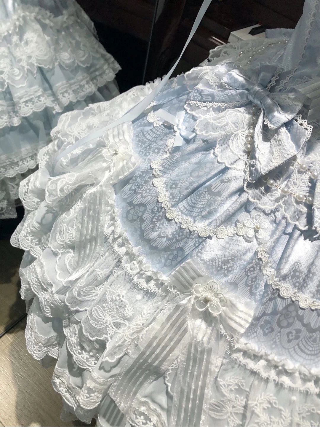 Creamy blue JSK dress with layered lace and bows on a mannequin