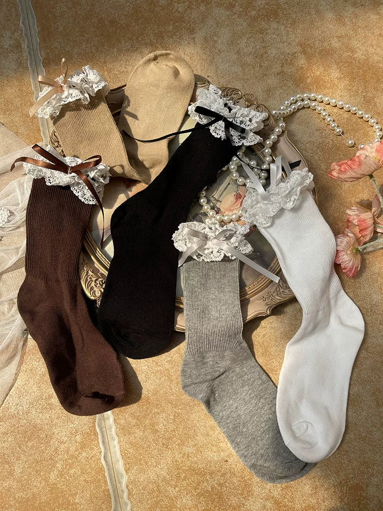 Black and khaki mid-calf socks with double lace cuffs and bow details styled with Mary Jane shoes.