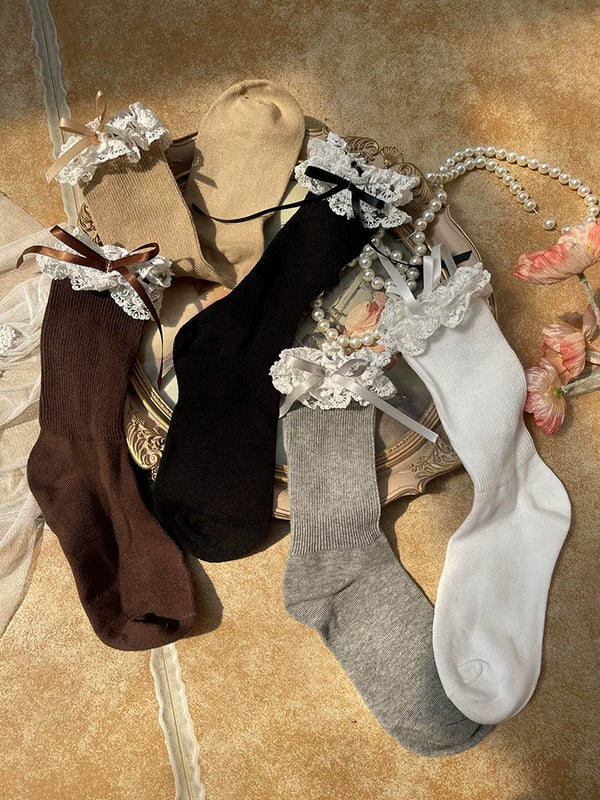 Black and khaki mid-calf socks with double lace cuffs and bow details styled with Mary Jane shoes.