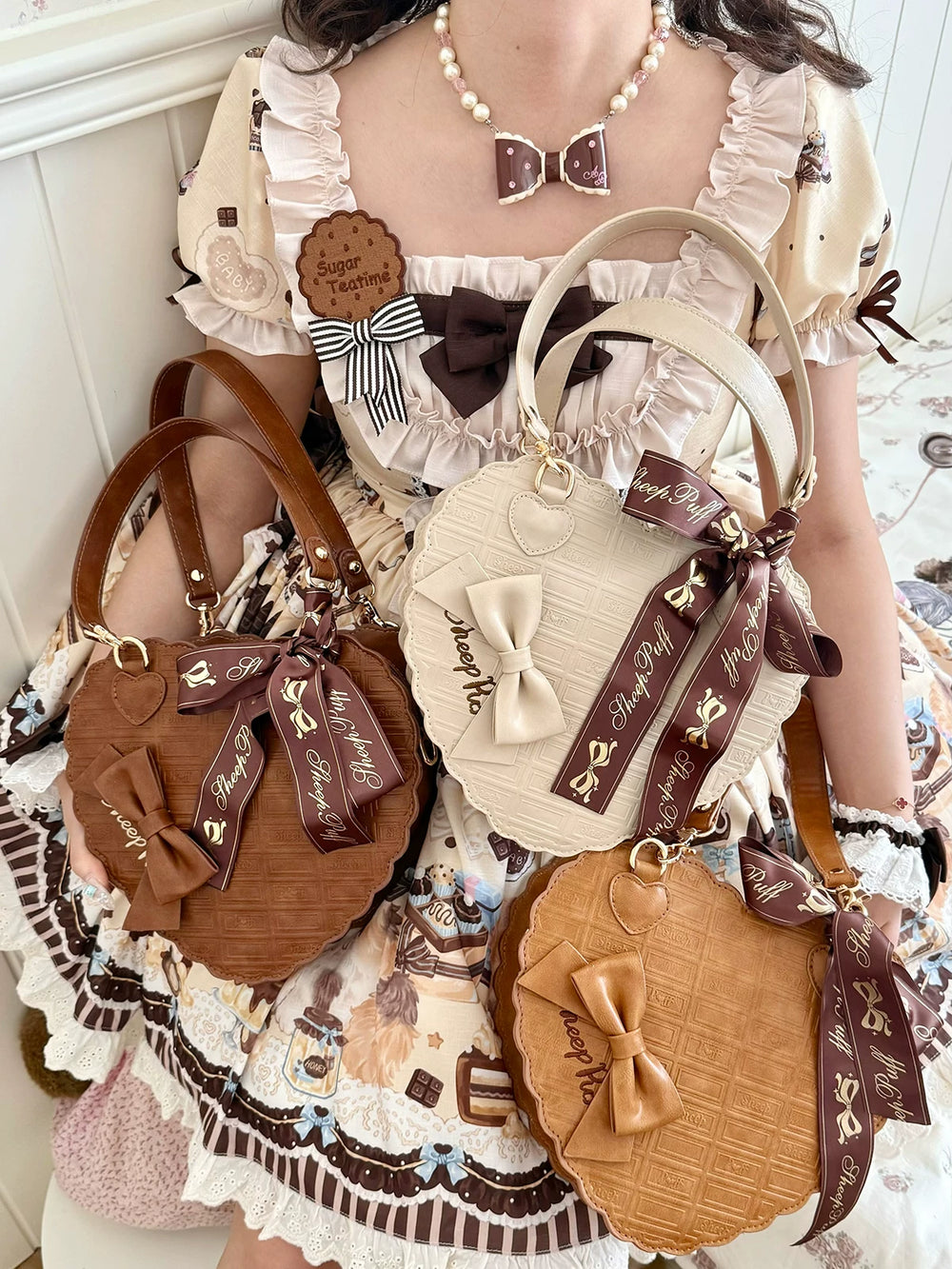 Three sheeppuff heart-shaped handbags in Light brown, Dark brown, and Grayish white, shown with bows and chocolate-textured fronts.