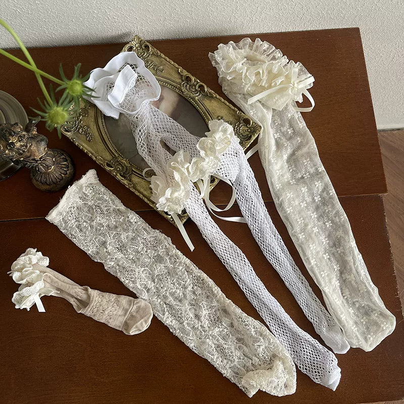 White fishnet tights layered with lace thigh bands and long lace socks