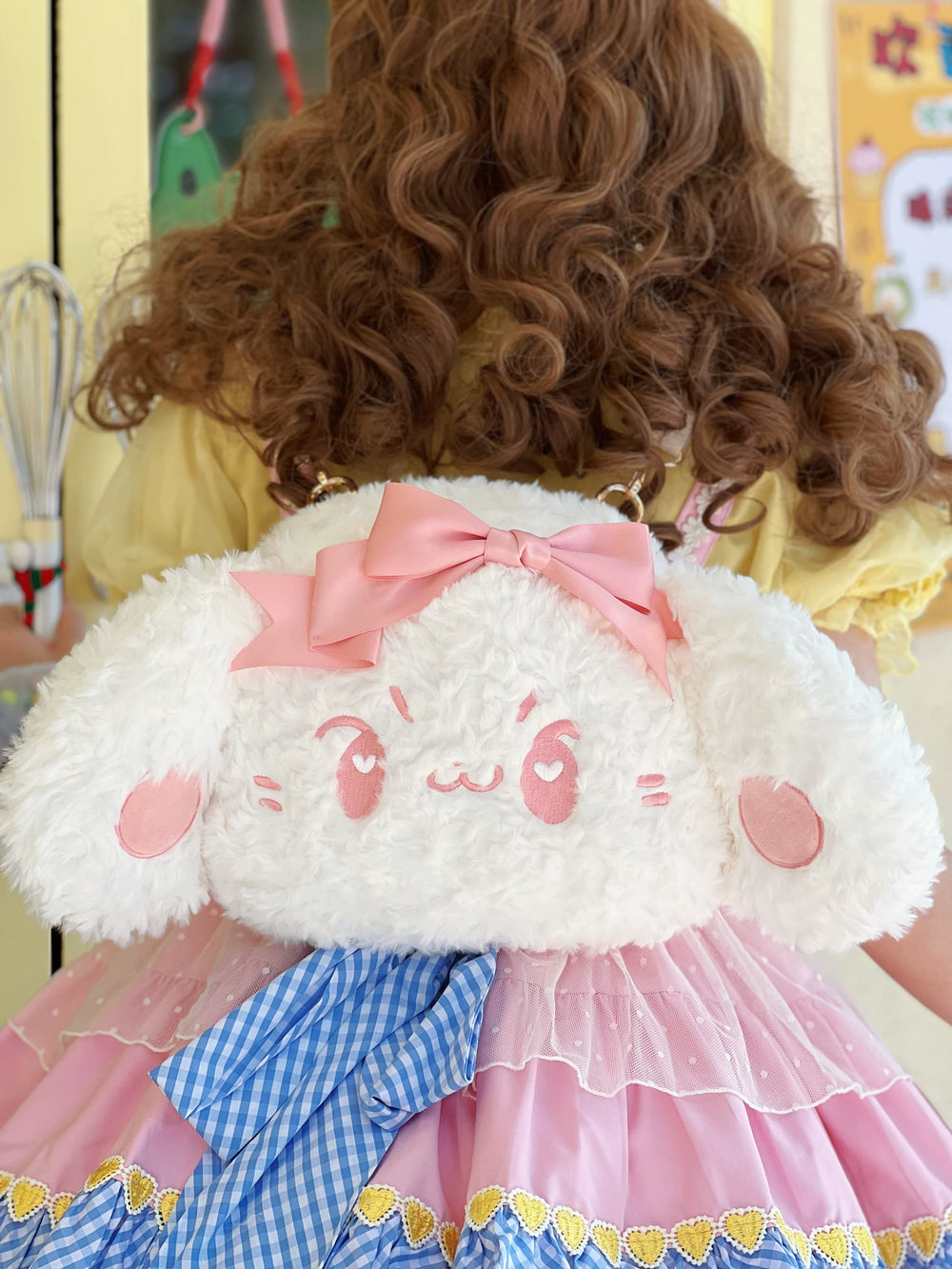 White plush dog bag with a large pink bow shown in crossbody and backpack styling.