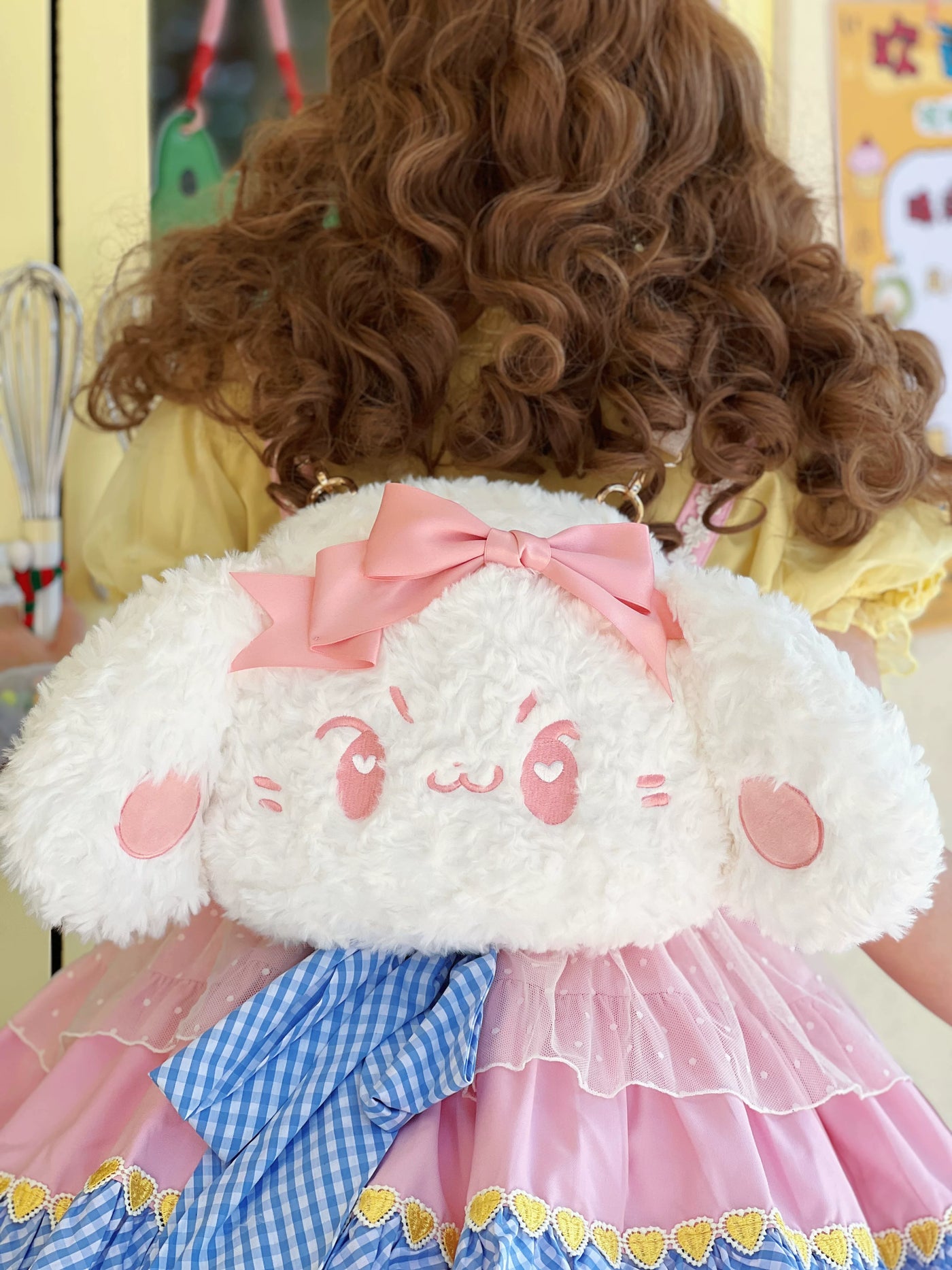 White plush dog bag with a large pink bow shown in crossbody and backpack styling.