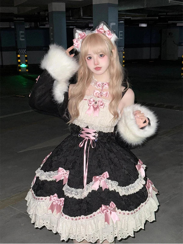 Model wearing a black lace-trimmed dress with pink bows and furry black outerwear.