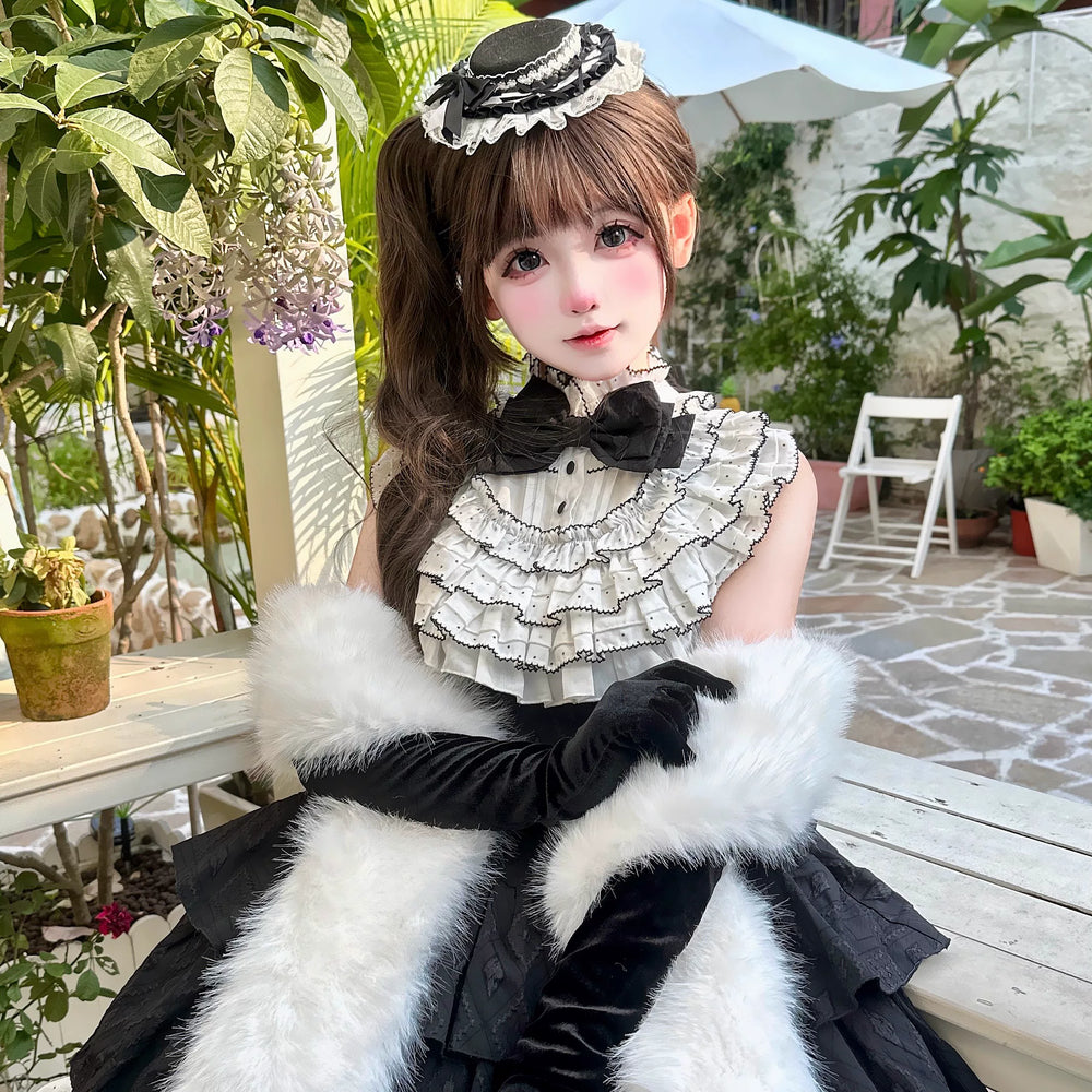 Model wearing a black one-piece dress with a white ruffle collar and layered full skirt.