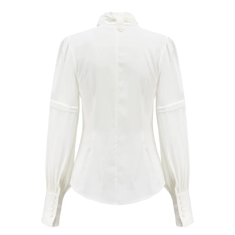 Pink long-sleeve blouse with a bow jabot and ruffled front detailing.