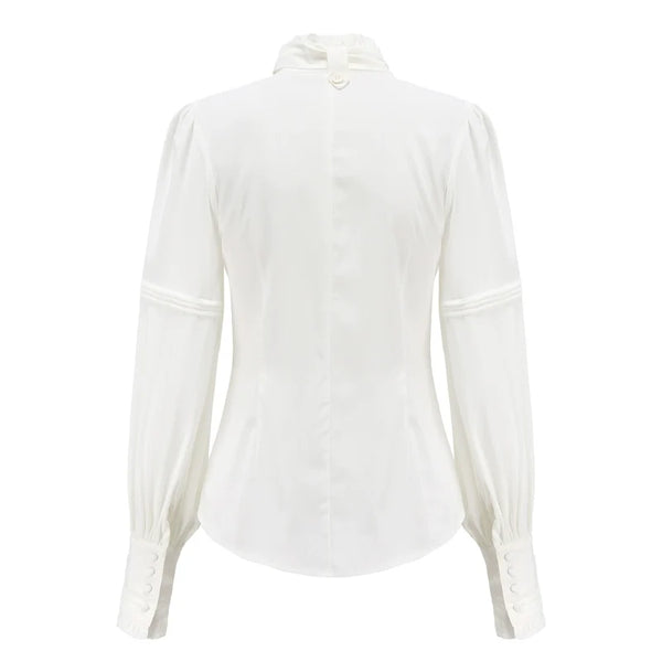 Pink long-sleeve blouse with a bow jabot and ruffled front detailing.