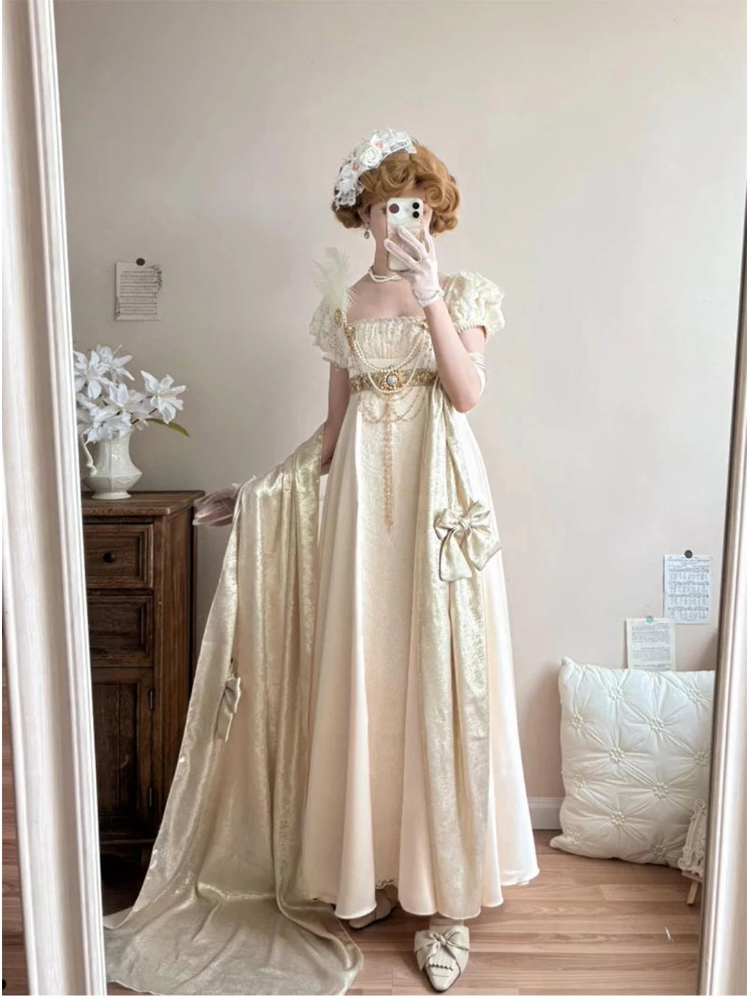 Ivory long dress and stole set with puff sleeves and waist ornament details shown in a mirror.