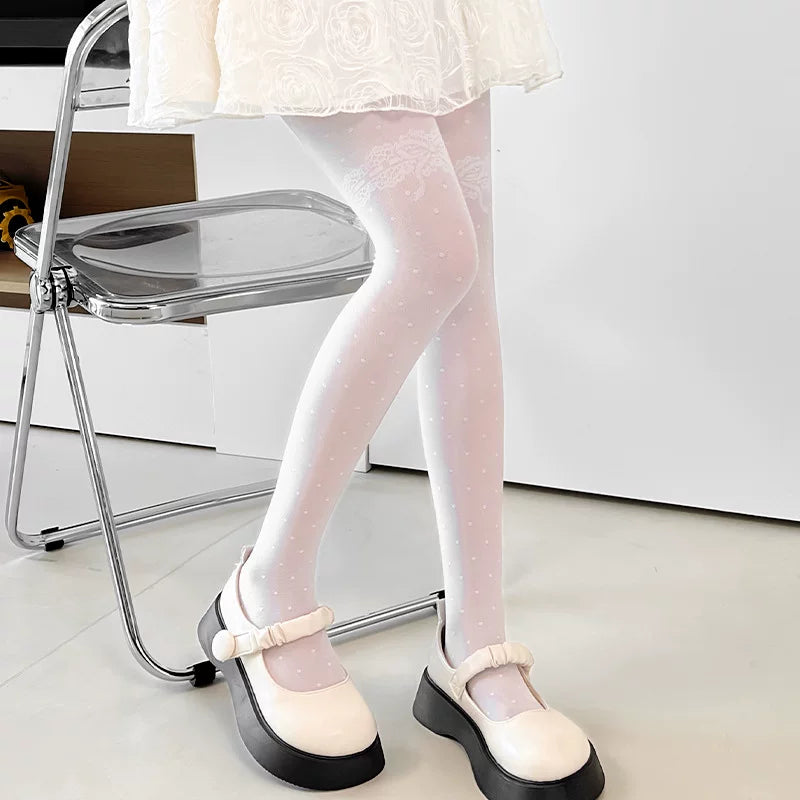 Black dotted tights with a lace thigh motif styled beneath a black skirt.
