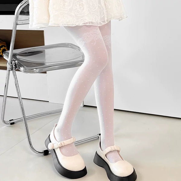 Black dotted tights with a lace thigh motif styled beneath a black skirt.