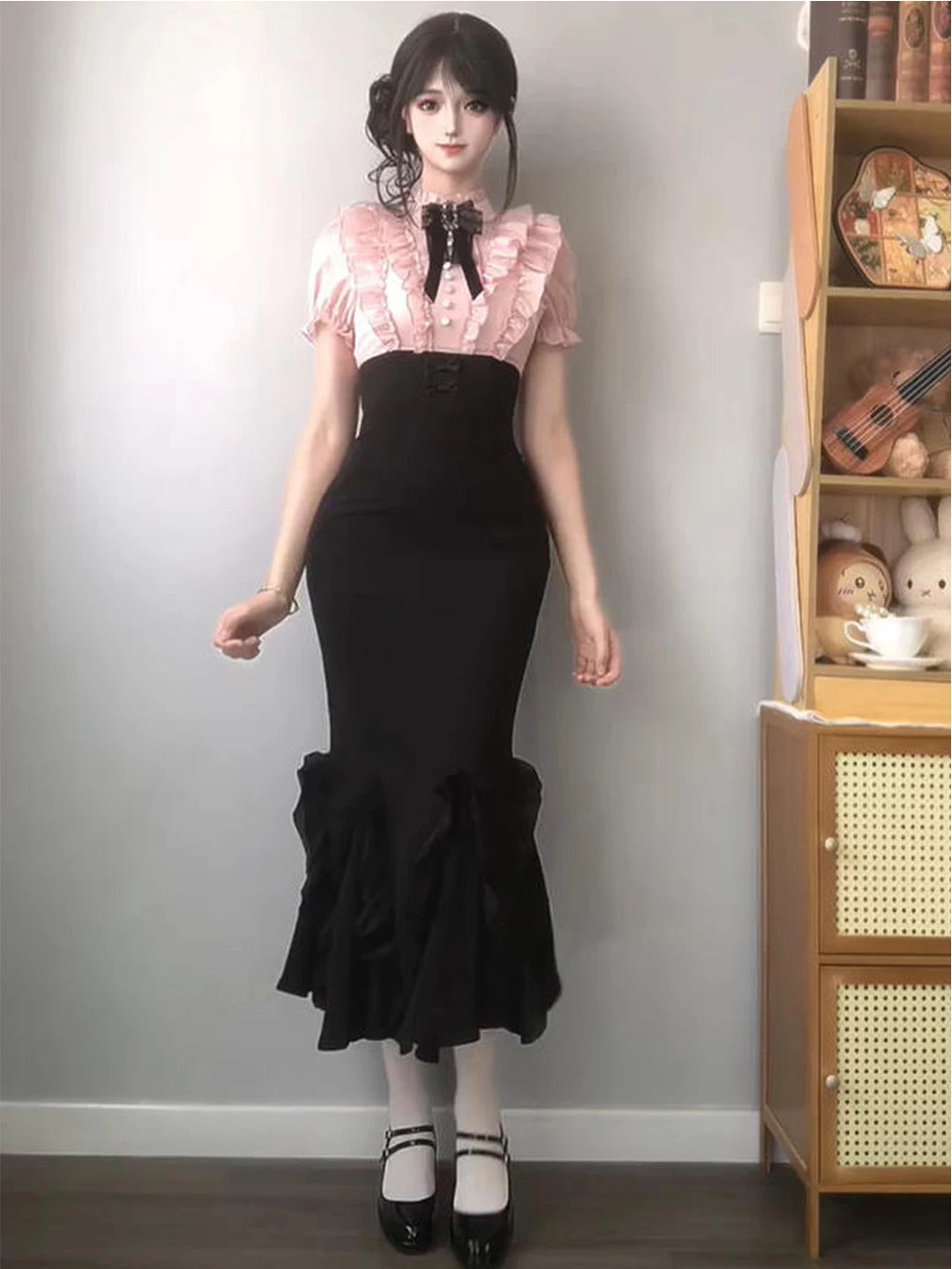 Black and pink mermaid one-piece dress with a lace-trimmed pink bodice and ruffled hem.