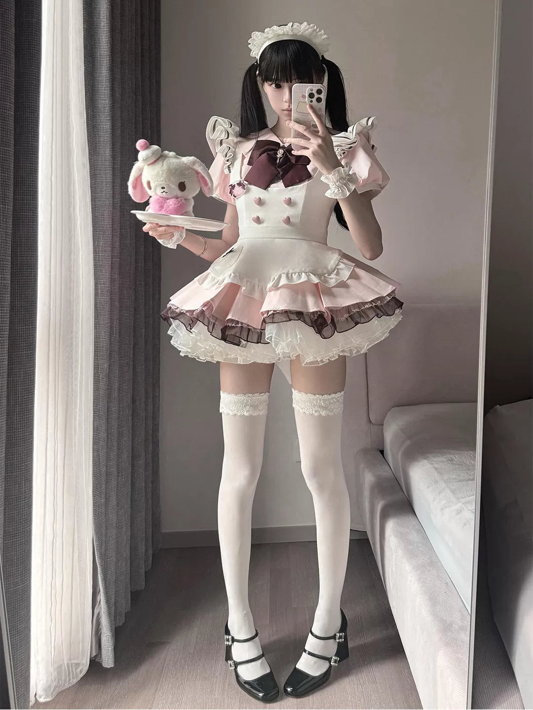White-and-pink one-piece Lolita dress with a maid apron, ruffled sleeves and layered skirt.