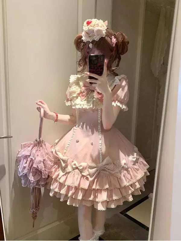 Pink striped tiered Lolita dress with bows and layered ruffles, shown in a mirror.
