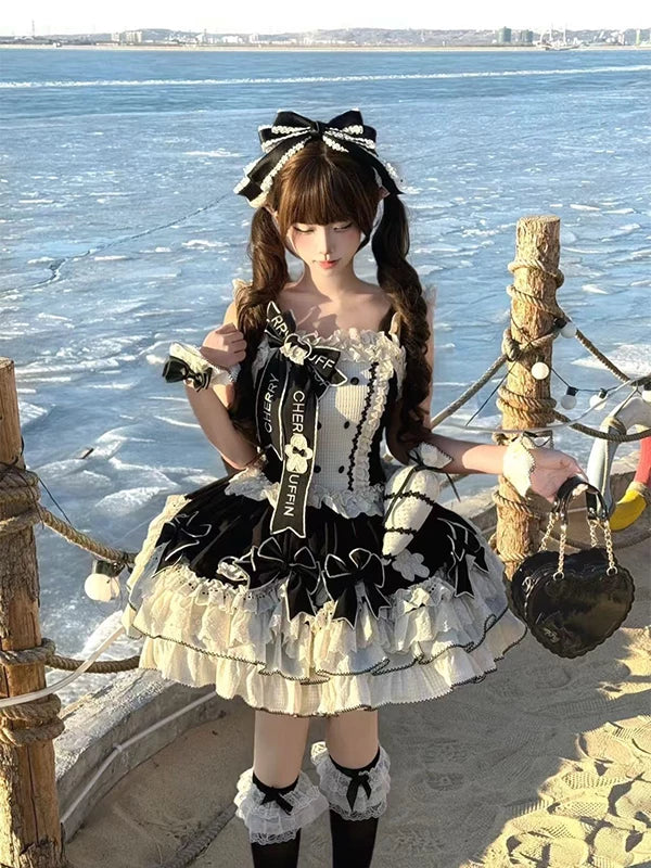 Black-and-white JSK dress set with cape, train, bows and layered ruffles worn outdoors.