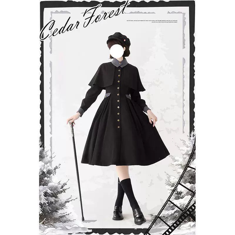 Gray-blue coat with a capelet overlay, dark collar and front buttons in a framed editorial image.