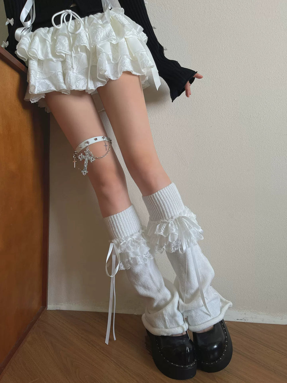 White knit sock covers with layered lace ruffles, bows, and long ribbon ties.