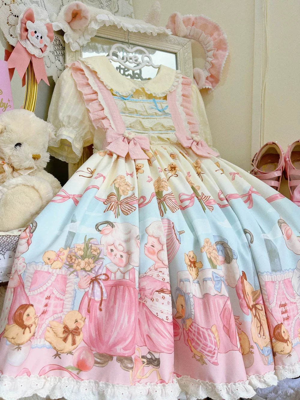 Pastel printed JSK with pink bows and a lace-trimmed hem on a mannequin.