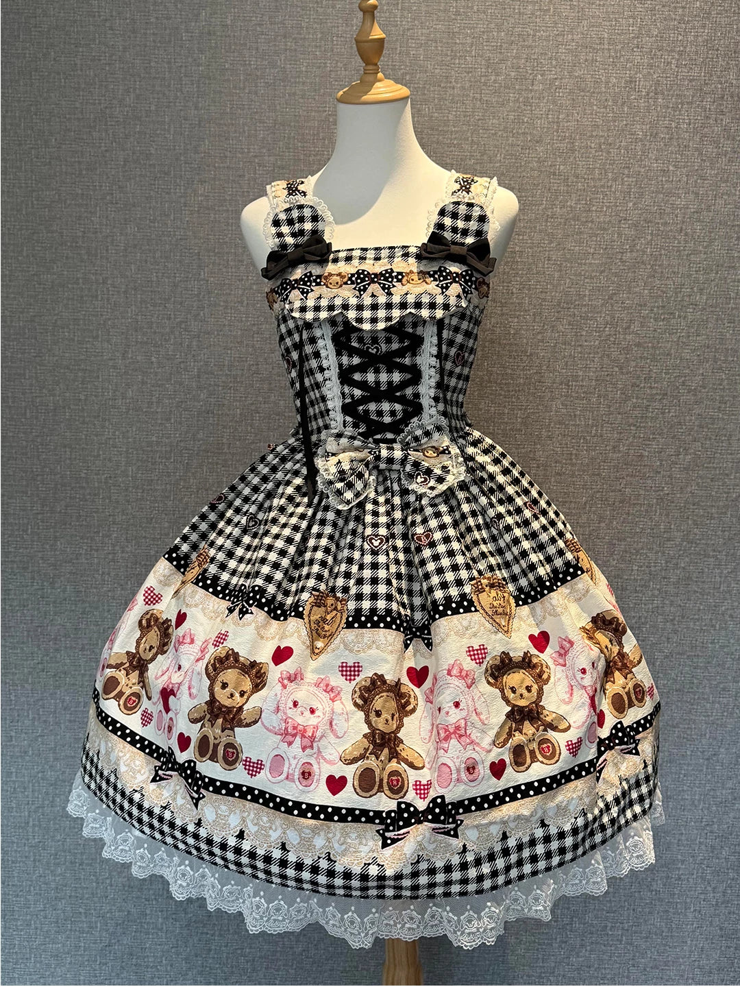 Creamy black-and-white plaid JSK dress with a bear print panel on a mannequin