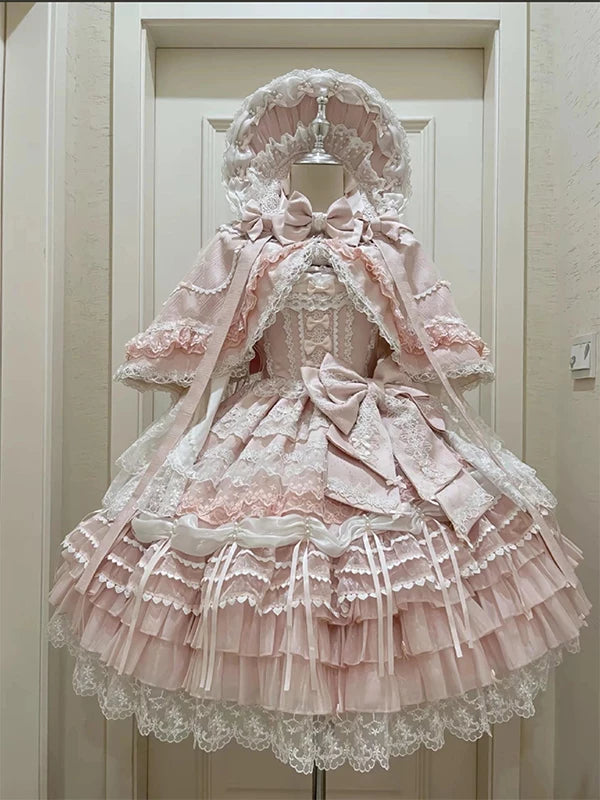 Blush pink lolita JSK set with lace-trimmed bonnet and sheer capelet displayed on mannequin