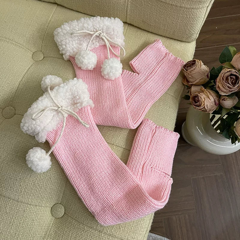 Black ribbed knit leg warmers with fluffy white cuffs and pom-pom ties