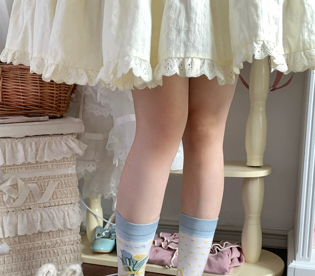 Pastel tulip-and-bow socks arranged on a wicker basket.