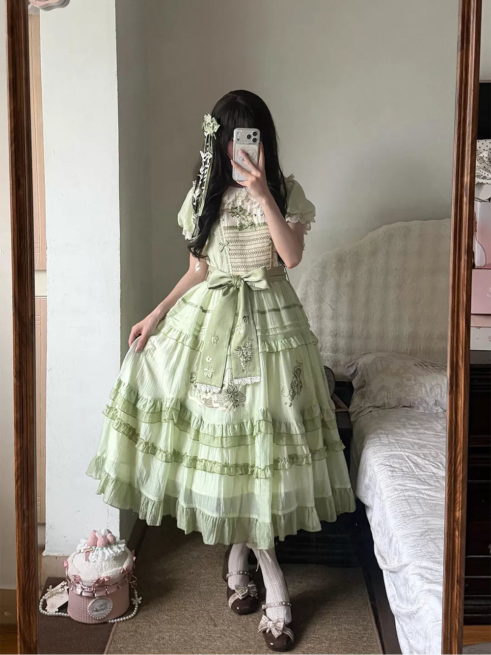 Pale green OP dress with embroidered motifs and layered ruffles shown in a mirror outfit photo.