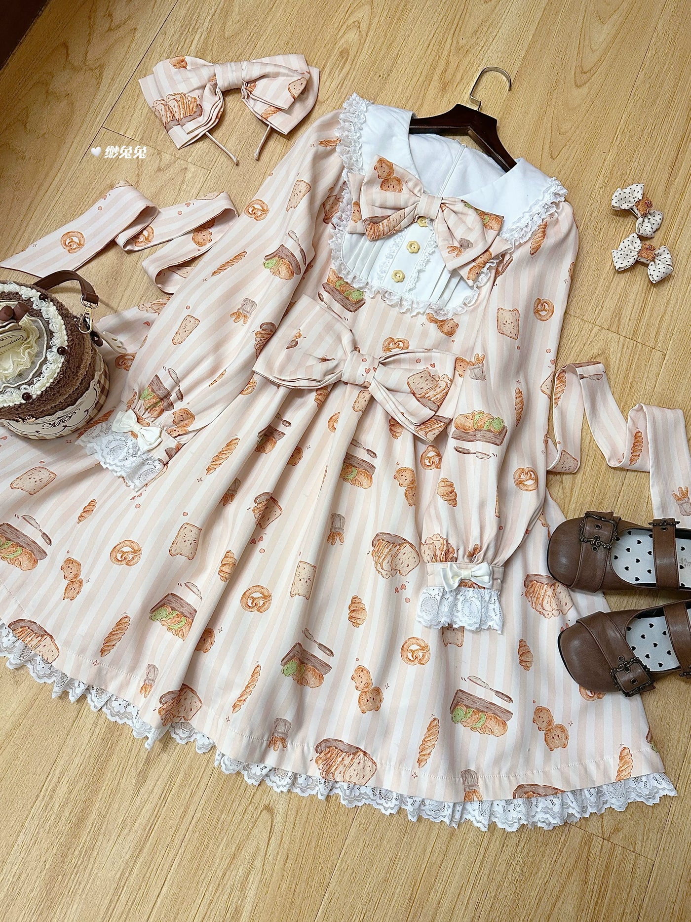 Pink long-sleeve sweet Lolita OP dress with bread and pastry print, lace trim, and chest bow